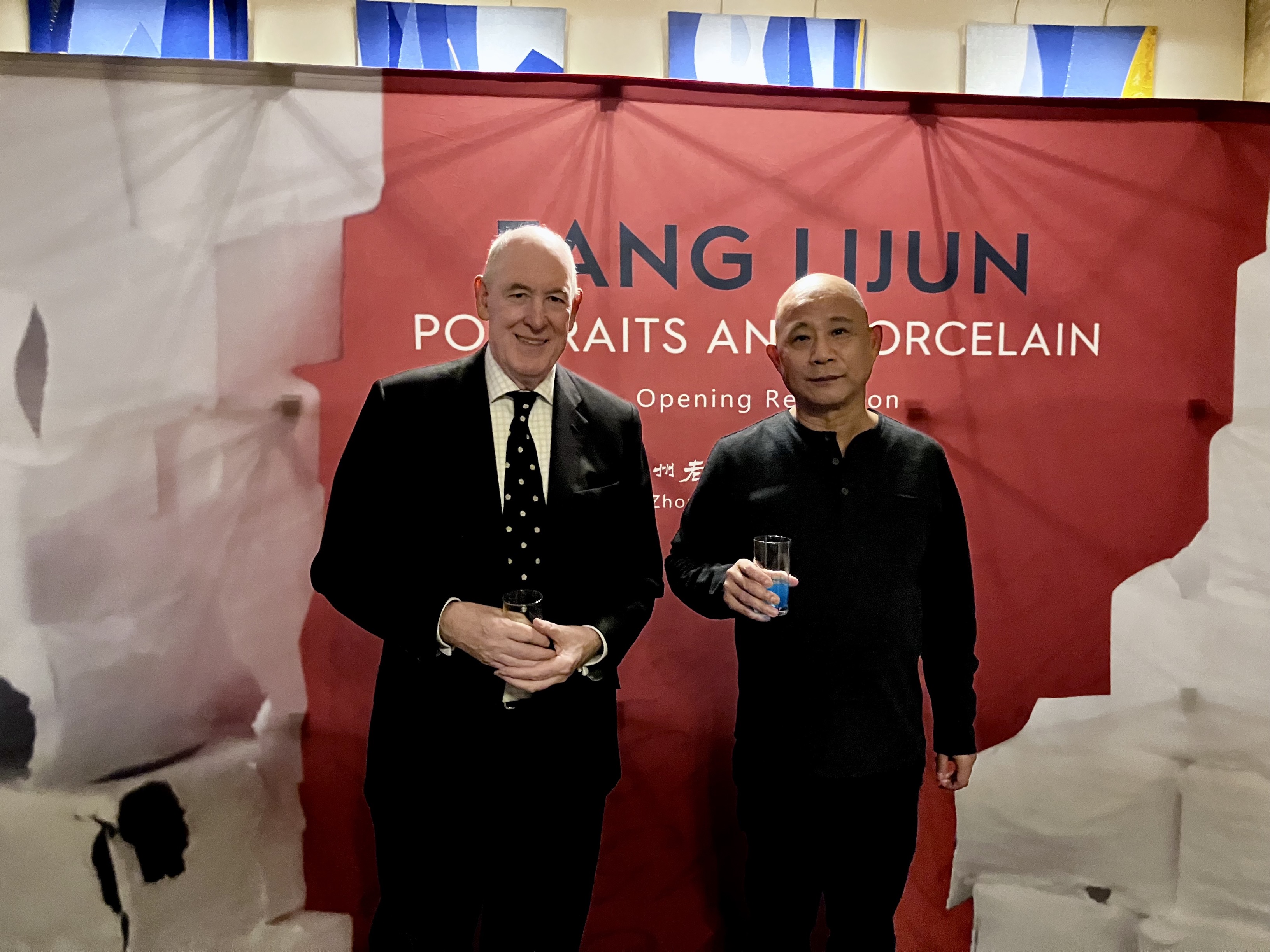 Fang Lijun and Miles Young standing in front of the exhibition banner