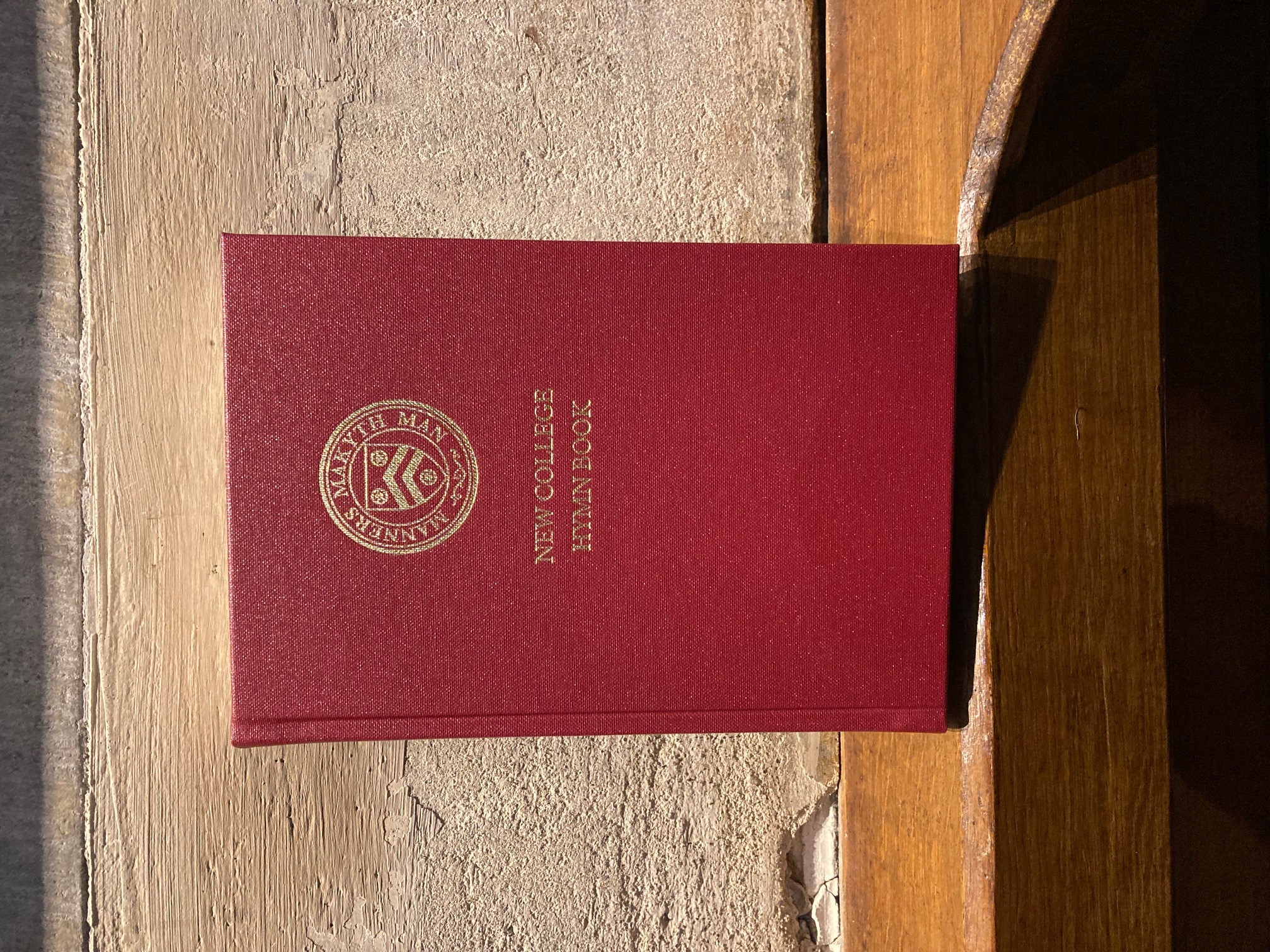 New College Hymn Book - gold writing on red cover