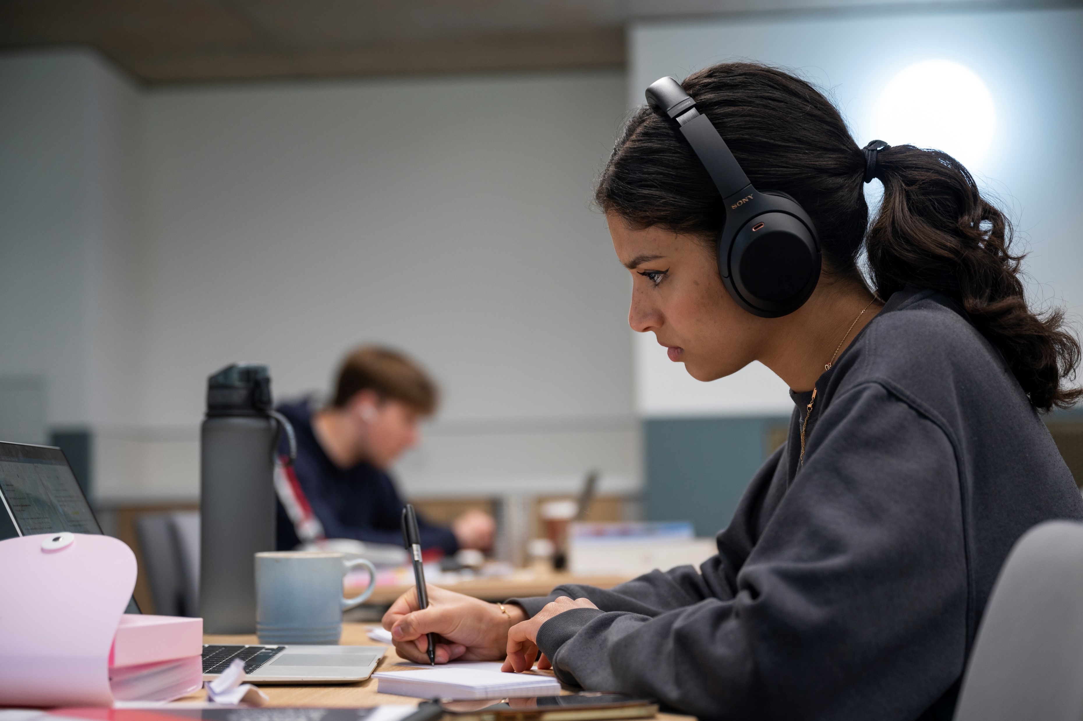 Student, wearing headphones, studies in the Gradel study space