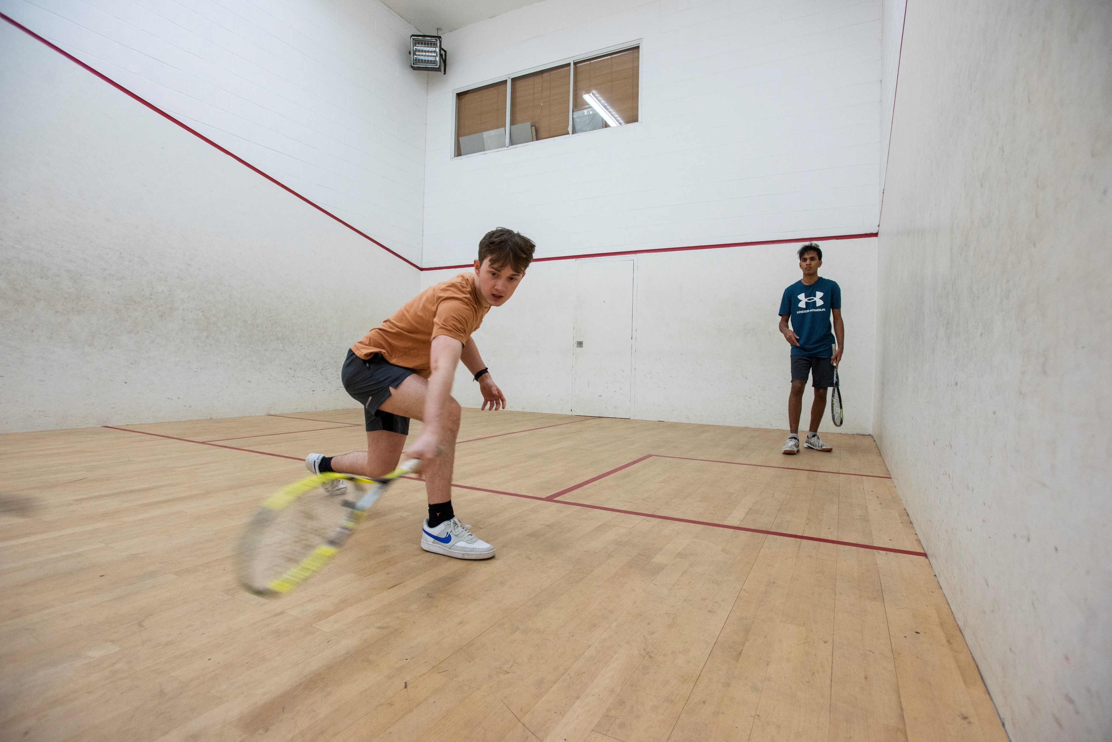 Two students play squash in the Weston Sports Ground