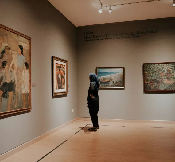 A person looking at paintings in an art gallery