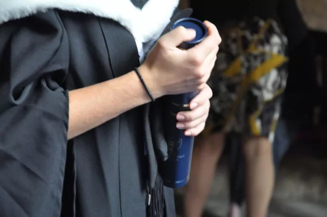 Student holding graduation certificate