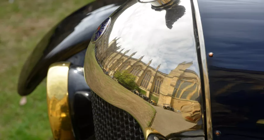 Old Morris car with New College Chapel reflecting in burnished nose