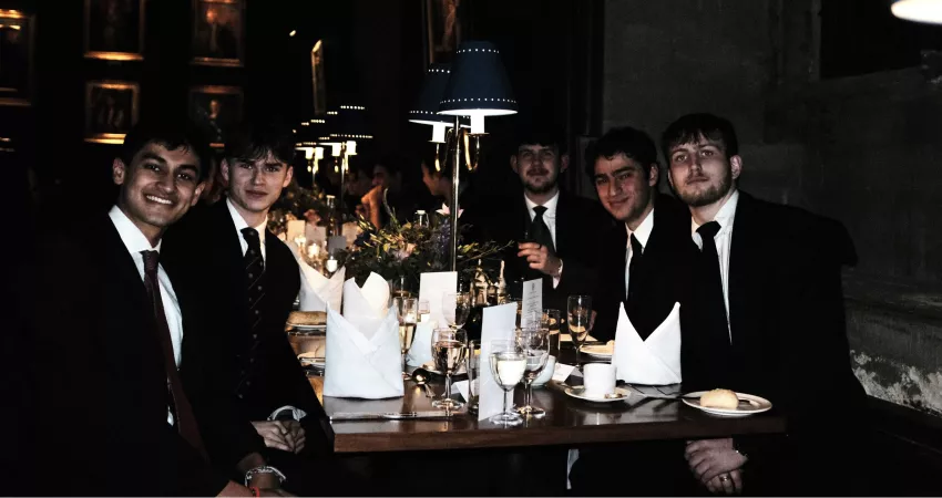 Students in formal dress sat at a table