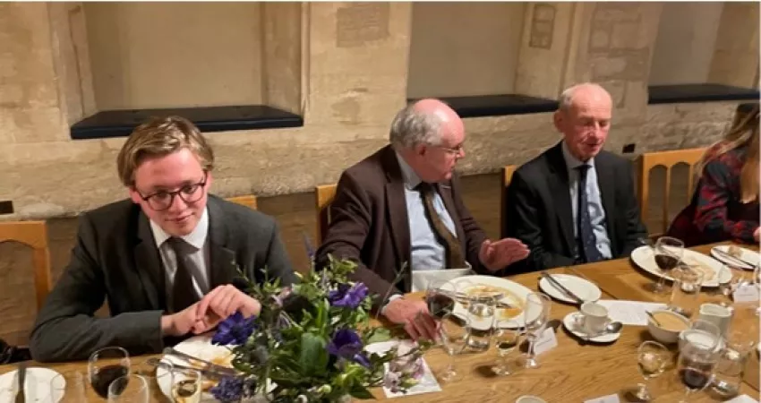 Three men conversing over dinner