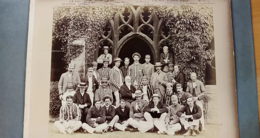 Black and white photos of men in suits and hats posed in cloisters
