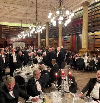 New College Old Members gathered around tables in a spectacular hall with chandeliers