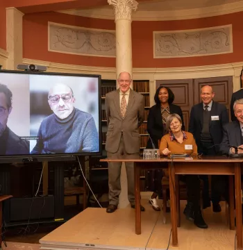 The panel participants, with two on screen attending virtually