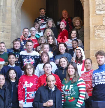 Staff in Christmas jumpers on the Hall stairs