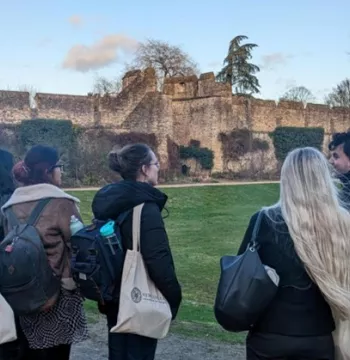 Students having a tour of New College, stood by the medieval City Wall