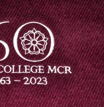 Sewn '60 New College MCR 1963-2023' in white on a burgundy background