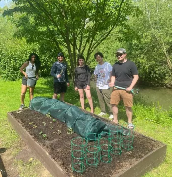 Five MCR students finish planting the vegetable patch at the Weston Buildings