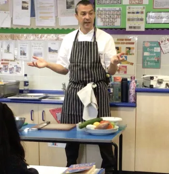Head Chef, Sam, gives his culinary masterclass to Year 4 pupils in a classroom